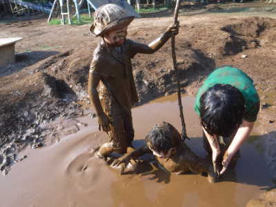 （写真）泥だらけになって遊ぶ子ども。