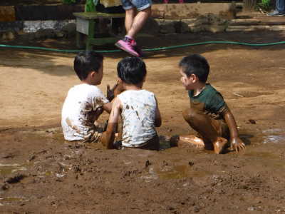 （写真）どろんこ遊びをする子どもたち。