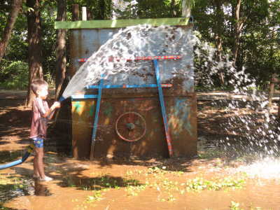（写真）ホースから水を出す子ども。