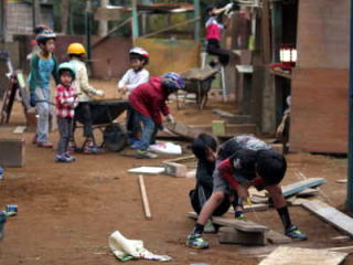 （写真）木材をノコギリで切ったり、運んだりと作業をする子どもたち