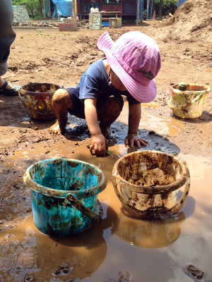 （写真）泥遊びをする子ども